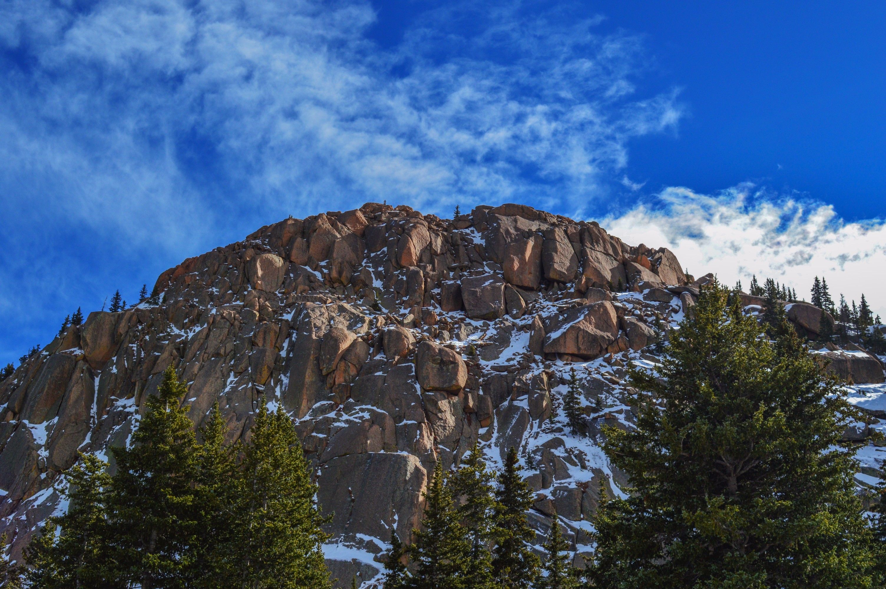 Snow-dusted granite peak and evergreen forest in the Colorado mountains near Denver